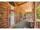 View of log cabin with rustic porch featuring a door, window, bench and warning sign posted nearby at 3360 Se 183Rd Avenue Rd, Ocklawaha, FL 32179