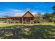 Back view of a log home with metal roof, complete with a spacious porch and a well-maintained yard at 3360 Se 183Rd Avenue Rd, Ocklawaha, FL 32179