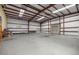 This is an interior view of the warehouse, revealing an expansive space with a high ceiling and roll-up door at 3360 Se 183Rd Avenue Rd, Ocklawaha, FL 32179