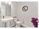 This neutral powder room features a pedestal sink, modern toilet, and wood look tile at 4306 Nw 54Th Ter, Ocala, FL 34482