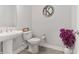 This neutral powder room features a pedestal sink, modern toilet, and wood look tile at 4306 Nw 54Th Ter, Ocala, FL 34482