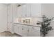 A well-appointed butlers pantry features white cabinets, drawers, and a patterned tile backsplash at 4306 Nw 54Th Ter, Ocala, FL 34482