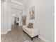 Bright hallway featuring a decorative ceiling, wood-look tile flooring, a bench, and art at 4306 Nw 54Th Ter, Ocala, FL 34482