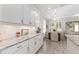 Bright kitchen featuring white cabinetry, granite countertops, and an adjacent dining area at 4306 Nw 54Th Ter, Ocala, FL 34482