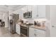 Gourmet kitchen with stainless steel appliances, white cabinets, and a tile backsplash at 4306 Nw 54Th Ter, Ocala, FL 34482