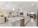 Bright, open kitchen features white cabinetry, a large island with seating, and stainless appliances at 4306 Nw 54Th Ter, Ocala, FL 34482