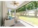 Relaxing screened patio featuring a ceiling fan, comfortable seating, and views of the lush green backyard at 4306 Nw 54Th Ter, Ocala, FL 34482