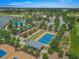 Overhead shot of a tennis court and recreation area within a golf course community that includes lush greenery at 4306 Nw 54Th Ter, Ocala, FL 34482