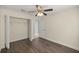 Bedroom with hardwood floors, ceiling fan, closet, and entry to the bathroom at 4324 Sw 98Th Ln, Ocala, FL 34476