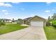 View of the home's well-maintained exterior with a spacious driveway and green lawn at 4324 Sw 98Th Ln, Ocala, FL 34476