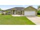 Charming home featuring a well-manicured lawn and attached two-car garage at 4324 Sw 98Th Ln, Ocala, FL 34476