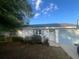 Charming single-story home with blue garage door, mature landscaping and blue skies at 45 Hickory Track Way, Ocala, FL 34472