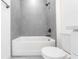 Modern bathroom featuring gray tile, quartz countertops and a shower-tub combo at 455 Marion Oaks Dr, Ocala, FL 34473