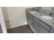 Bathroom featuring a double vanity with granite countertops and gray cabinetry at 5077 Stokes Way, Wildwood, FL 34785