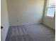Bedroom featuring plush gray carpet, white walls, and a window bringing in natural light at 5077 Stokes Way, Wildwood, FL 34785