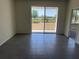 Living room with tile flooring and sliding glass doors that lead to the outside at 5077 Stokes Way, Wildwood, FL 34785