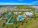A beautiful aerial view of community amenities including a pool, tennis courts, and a clubhouse with palm trees at 5220 Sunshine Dr, Wildwood, FL 34785