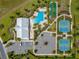 Aerial shot of a community clubhouse, parking area, pool, bocce ball court, and tennis courts at 5220 Sunshine Dr, Wildwood, FL 34785