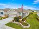 A home in a community of homes, featuring lovely landscaping, an American flag, and manicured lawns at 5220 Sunshine Dr, Wildwood, FL 34785