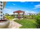 Manicured backyard featuring lush lawn and a pergola with outdoor seating at 5220 Sunshine Dr, Wildwood, FL 34785