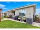Lush backyard with well-maintained lawn, paver patio, and covered outdoor seating area at 5220 Sunshine Dr, Wildwood, FL 34785