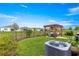 Large, grassy backyard featuring a pergola with seating, bordered by landscaping and fencing at 5220 Sunshine Dr, Wildwood, FL 34785