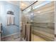 Modern bathroom featuring a glass-enclosed shower with safety bars and a soothing color palette at 5220 Sunshine Dr, Wildwood, FL 34785