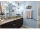 Bathroom with double granite vanity, modern lighting, and blue walls at 5220 Sunshine Dr, Wildwood, FL 34785