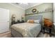 Cozy bedroom featuring decorative pillows and a large patterned comforter at 5220 Sunshine Dr, Wildwood, FL 34785