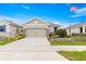 Charming home featuring a well-manicured lawn, a two-car garage, and an American flag at 5220 Sunshine Dr, Wildwood, FL 34785