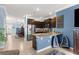 A modern kitchen with a granite island, stainless steel appliances, and open access to dining and living spaces at 5220 Sunshine Dr, Wildwood, FL 34785
