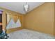 Bedroom with light gold walls, decorative window treatment, and elegant chandelier at 5350 Sw 82Nd St, Ocala, FL 34476