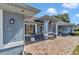 Covered front porch with stone walkway and seating area and light blue siding at 5350 Sw 82Nd St, Ocala, FL 34476