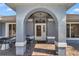 Covered front porch with stone walkway and seating area featuring an arched entry at 5350 Sw 82Nd St, Ocala, FL 34476