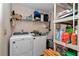 Functional laundry area features a washer, dryer, shelving, and essential cleaning supplies at 5350 Sw 82Nd St, Ocala, FL 34476