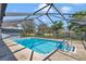 Enclosed swimming pool with a ladder, steps, a diving board, and an adjacent seating area at 5350 Sw 82Nd St, Ocala, FL 34476