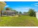 A sprawling backyard featuring a screened-in pool, patio set, a fire pit, and lush green grass at 5580 Se 21St Ln, Ocala, FL 34480