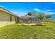 Grassy backyard with view of the screen-enclosed pool, patio seating, fire pit, and fenced yard, perfect for outdoor enjoyment at 5580 Se 21St Ln, Ocala, FL 34480