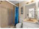 Bathroom featuring a shower, toilet, vanity with sink, and decorative wall shelf at 5580 Se 21St Ln, Ocala, FL 34480