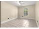 Comfortable bedroom featuring a ceiling fan and tile floors, illuminated by a window bringing in natural light at 5580 Se 21St Ln, Ocala, FL 34480