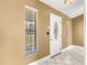 Bright foyer with tile flooring, a decorative door, and natural light streaming through the window at 5580 Se 21St Ln, Ocala, FL 34480