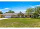 Charming single-story home with stone accents and a well-maintained lawn under a bright blue sky at 5580 Se 21St Ln, Ocala, FL 34480