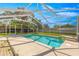 Clear in-ground pool in a screened enclosure with a sunny patio, perfect for outdoor entertainment and relaxation at 5580 Se 21St Ln, Ocala, FL 34480