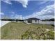 Large, fenced backyard with well-maintained lawn, shed, and mature trees under a sunny sky at 6365 Se 12Th Ln, Ocala, FL 34472