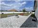 Backyard oasis features a brick paver patio with a fire pit, bench, and white vinyl fencing at 6365 Se 12Th Ln, Ocala, FL 34472
