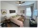 Comfortable bedroom featuring a ceiling fan and a bed with colorful quilt and green pillows at 6365 Se 12Th Ln, Ocala, FL 34472