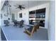 Relaxing covered patio with a ceiling fan, wooden swing, and sliding glass doors to the home's interior at 6365 Se 12Th Ln, Ocala, FL 34472