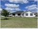 Inviting single-story home with a well-manicured lawn and sleek black window trim at 6365 Se 12Th Ln, Ocala, FL 34472