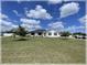 Charming single-story home with a well-manicured lawn, blue front door, and inviting curb appeal at 6365 Se 12Th Ln, Ocala, FL 34472