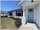 Charming front porch with a blue door, white pillar, and well-maintained landscaping at 6365 Se 12Th Ln, Ocala, FL 34472